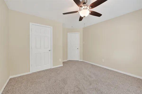 an empty room with chandelier fan
