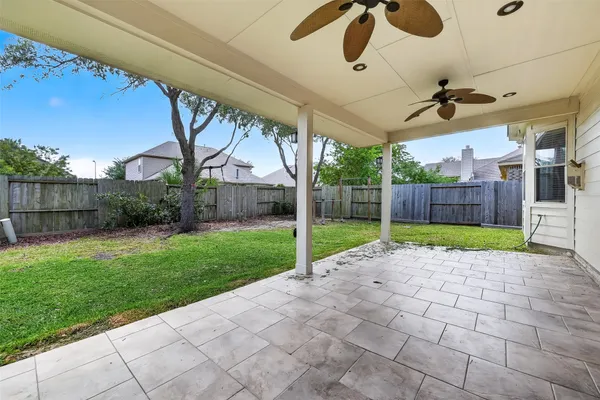 a view of a backyard with plants and wooden fence