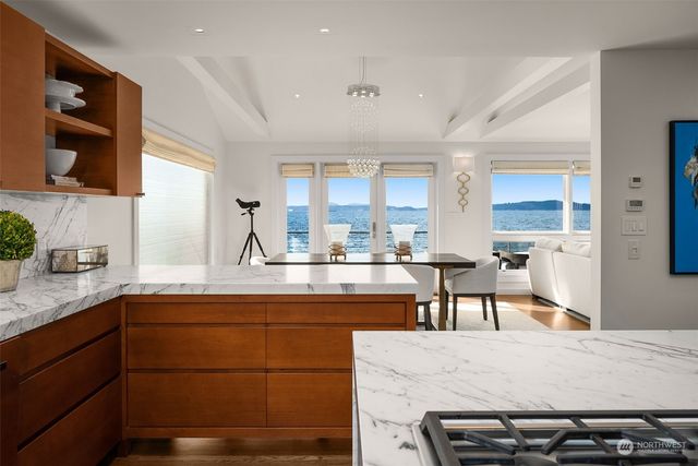 a kitchen with stainless steel appliances granite countertop table chairs sink and cabinets