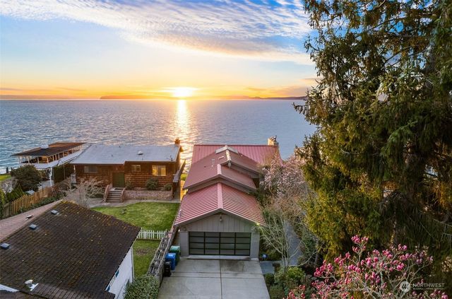 an aerial view of house with yard and ocean view