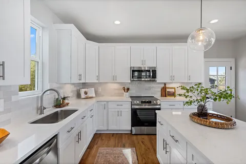 a kitchen with kitchen island granite countertop a sink stainless steel appliances and cabinets