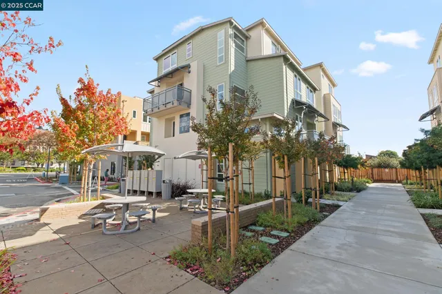a city street lined with tall buildings and cars parked on the roadside