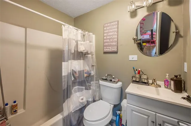 a white toilet sitting next to a bathroom sink and a mirror