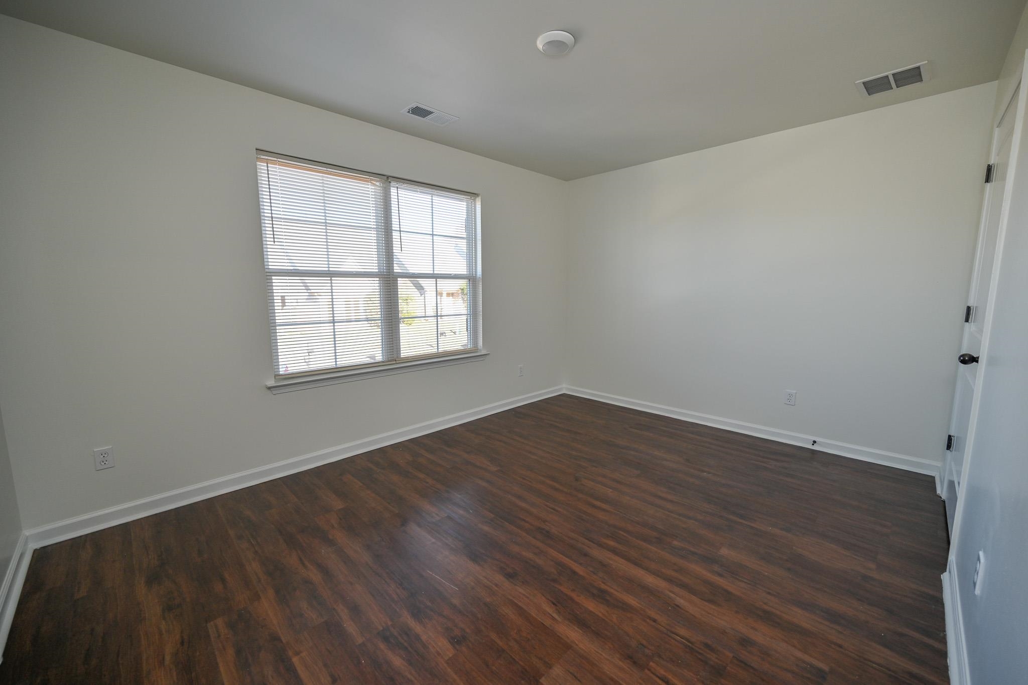10249 Sterling Ridge Drive Cordova, TN 38018 - Photo 20 of 27 an empty room with wooden floor and windows