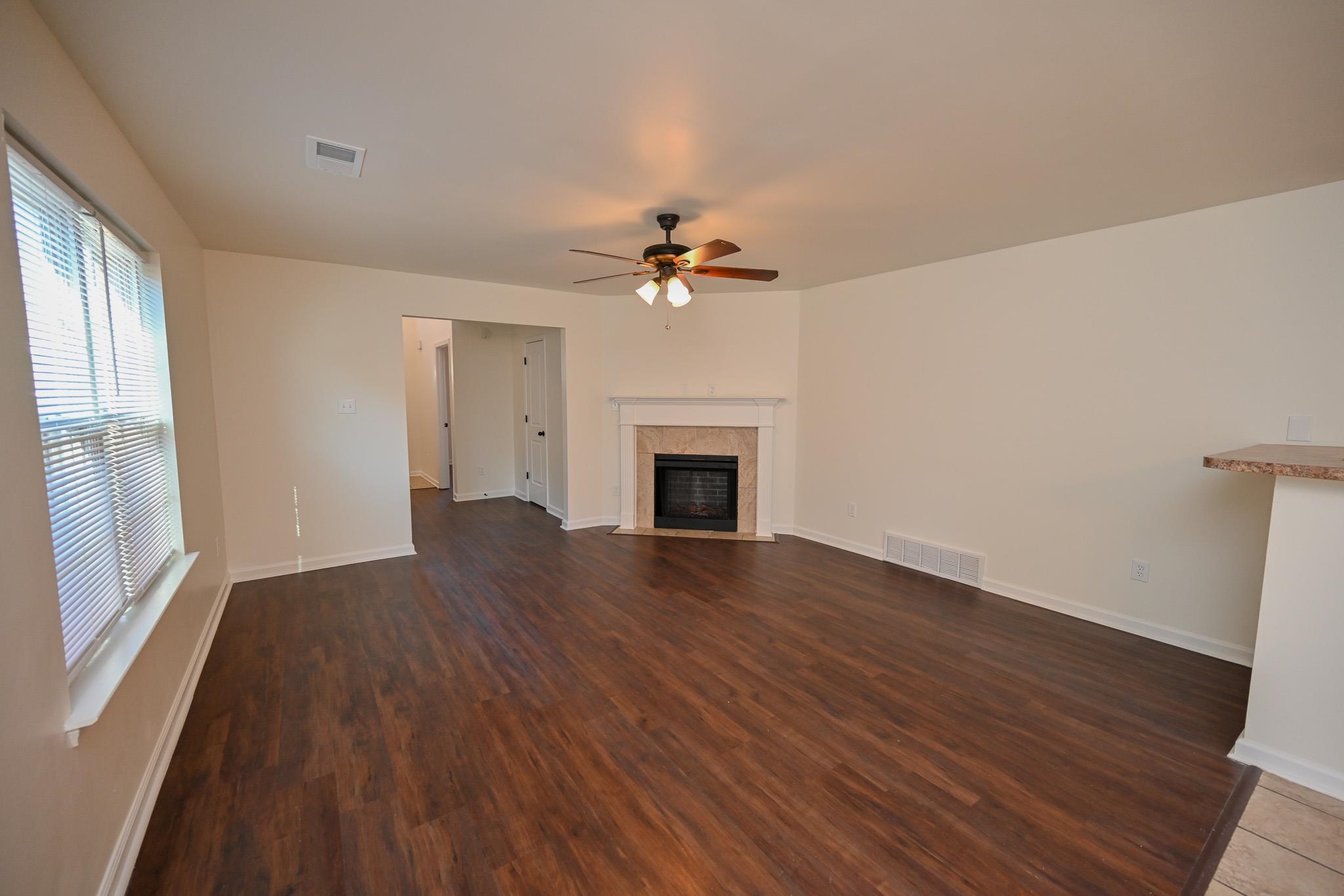 10249 Sterling Ridge Drive Cordova, TN 38018 - Photo 6 of 27 an empty room with wooden floor fireplace and windows