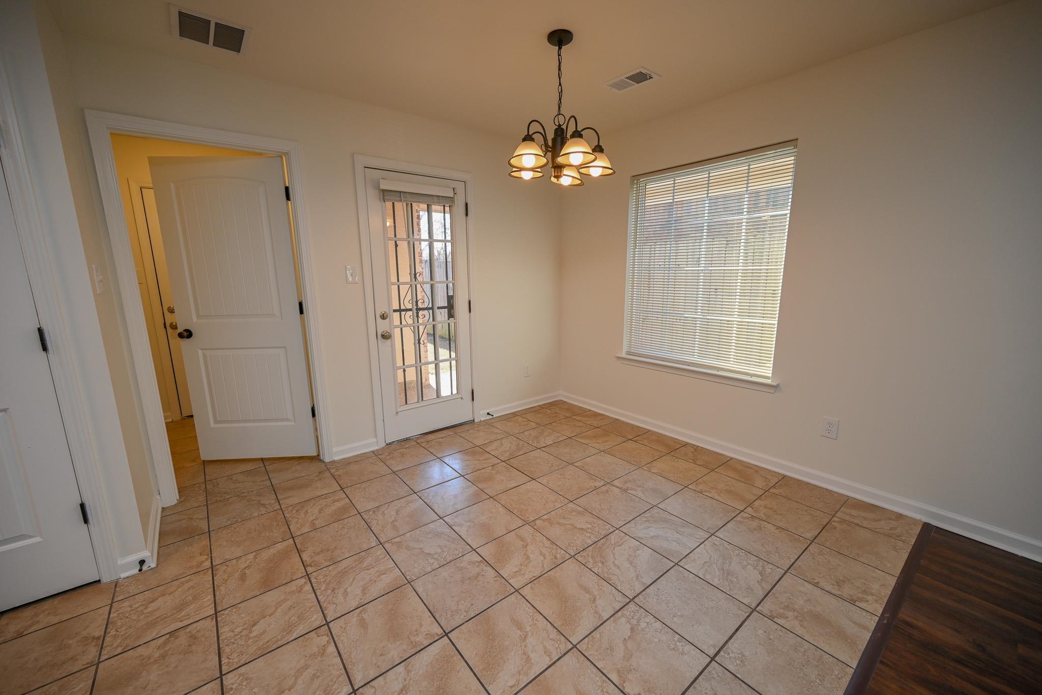 10249 Sterling Ridge Drive Cordova, TN 38018 - Photo 7 of 27 an empty room with chandelier fan and windows