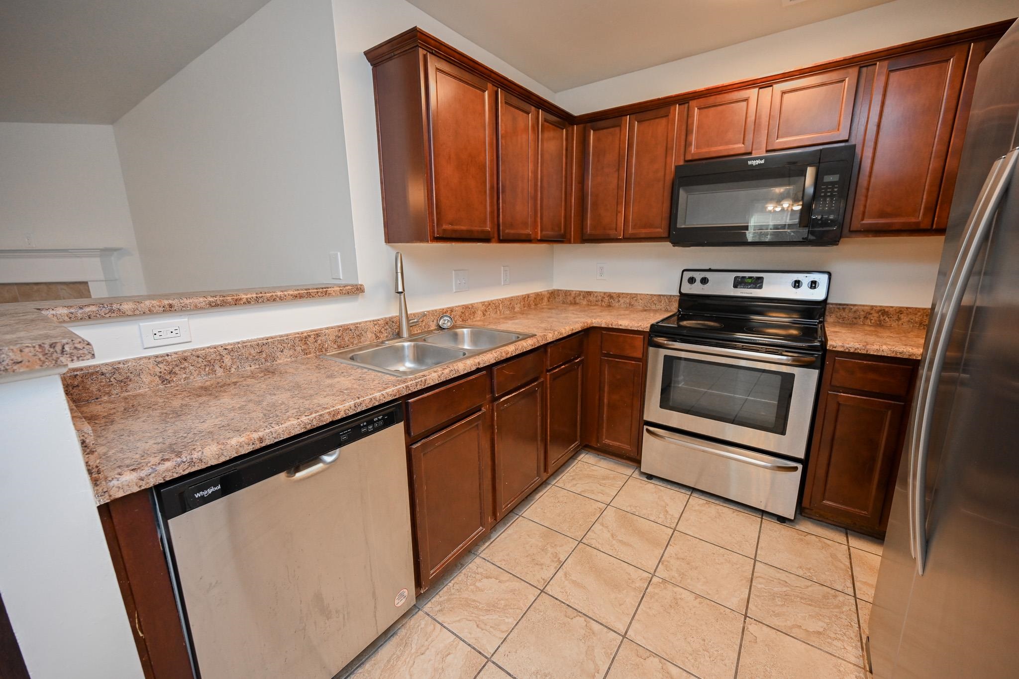 10249 Sterling Ridge Drive Cordova, TN 38018 - Photo 9 of 27 a kitchen with granite countertop a sink stove and microwave