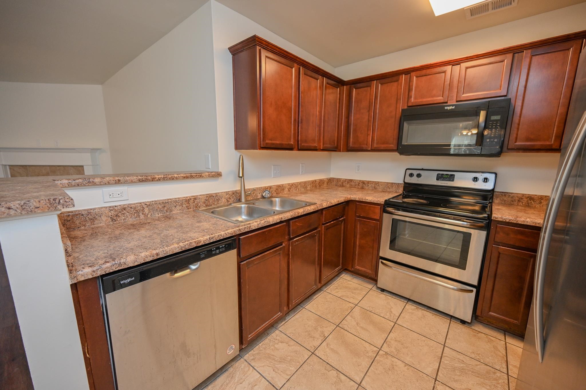 10249 Sterling Ridge Drive Cordova, TN 38018 - Photo 10 of 27 a kitchen with granite countertop a sink stove and microwave