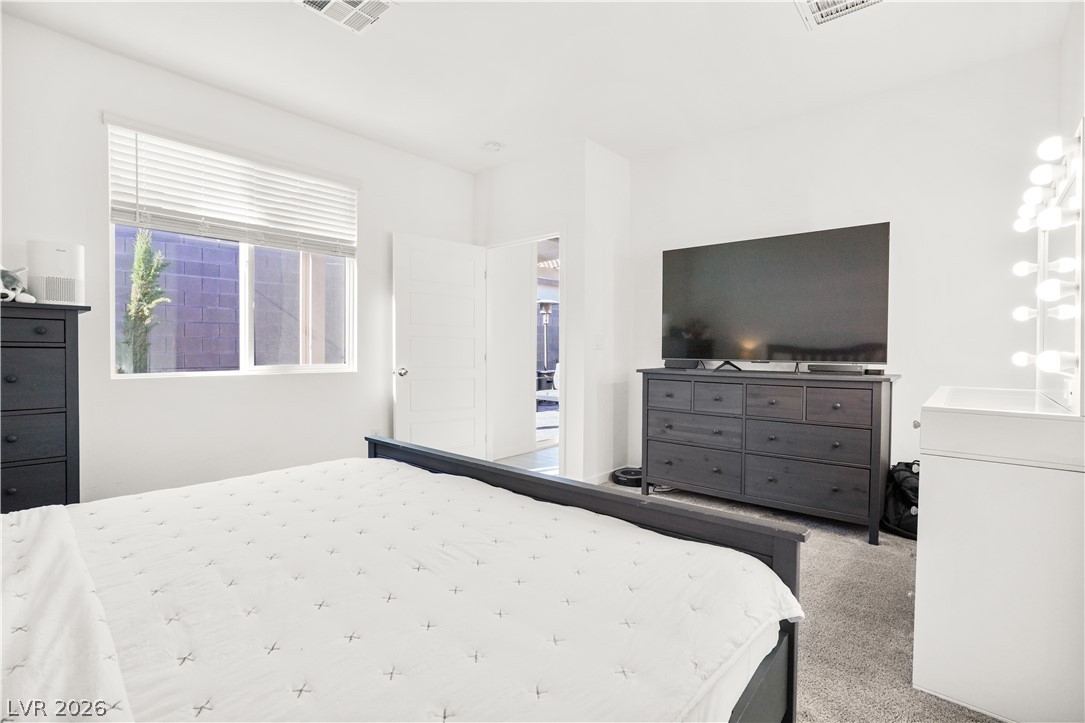 9398 Noble Fir Rdg Court Las Vegas, NV 89143 - Photo 14 of 36 A quiet retreat, this bedroom offers carpeted flooring and ample natural light through a large window with blinds.