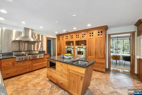a large kitchen with stainless steel appliances granite countertop a stove and a sink