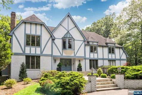 a front view of a house with a yard and potted plants