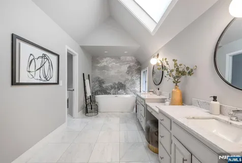 a spacious bathroom with a tub sink and mirror