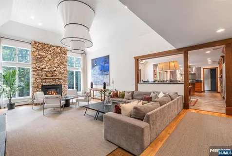 a living room with furniture fireplace and a large window