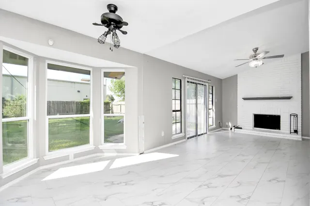 a view of an empty room with a fireplace and a window