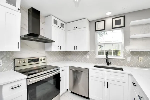 a kitchen with cabinets appliances a sink and a window