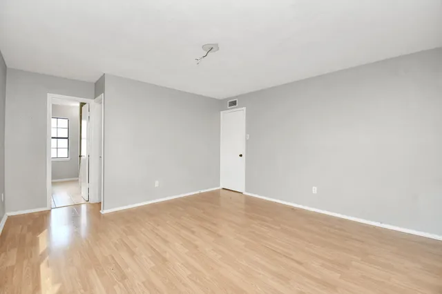 a view of an empty room with wooden floor