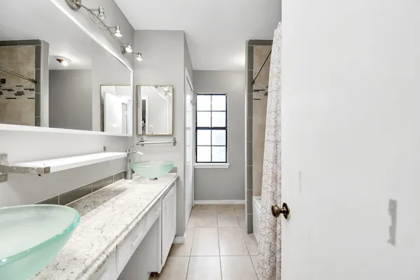 a spacious bathroom with a granite countertop tub sink and mirror