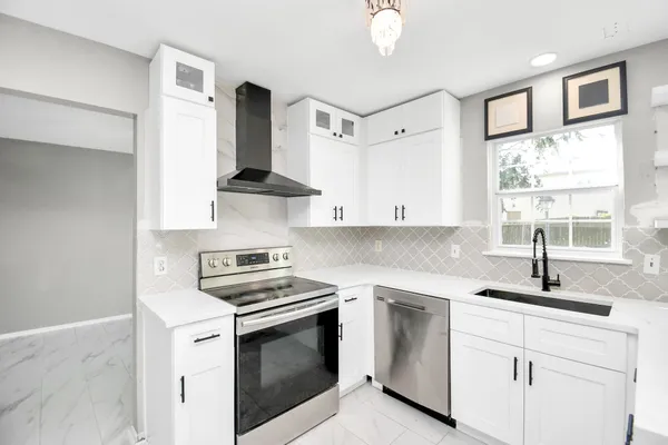 a kitchen with white cabinets and appliances