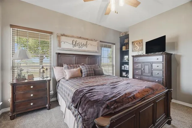 a bedroom with a bed and a flat tv screen on dresser
