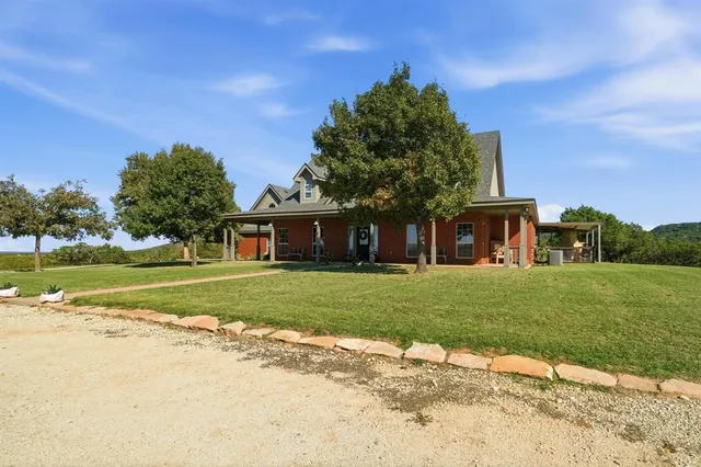 a front view of a house with a garden and trees