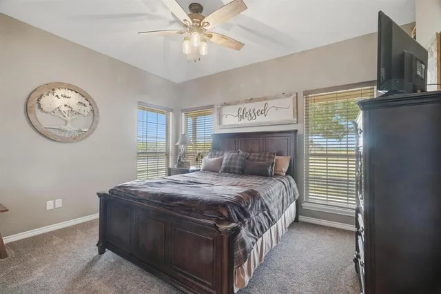 a bedroom with a bed and a large window