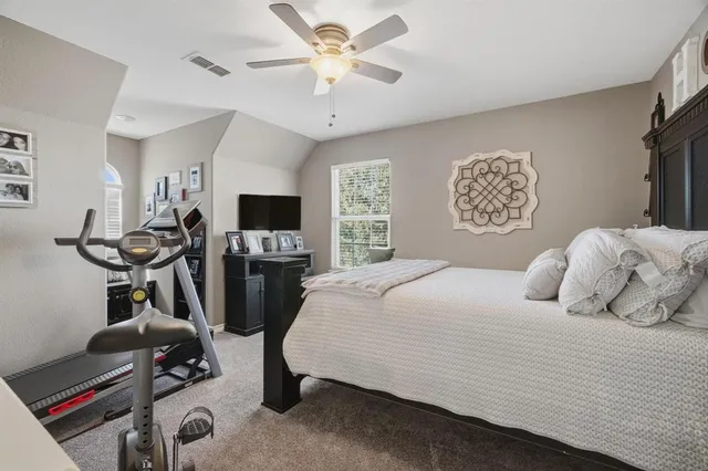 a bedroom with a bed a flat screen tv and a window