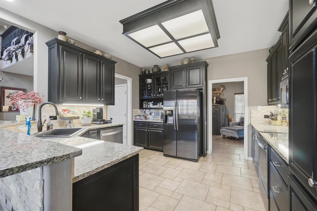 401 County Road 359, Unit B Merkel, TX 79536 - Photo 10 of 40 a kitchen with stainless steel appliances granite countertop a refrigerator oven a sink dishwasher and cabinets