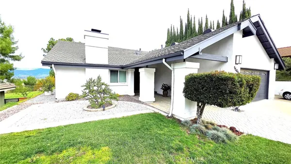 a view of a house with a yard and potted plants
