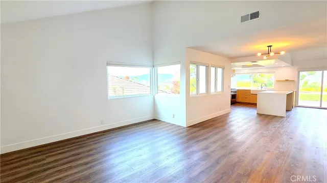 a view of a big room with wooden floor and windows