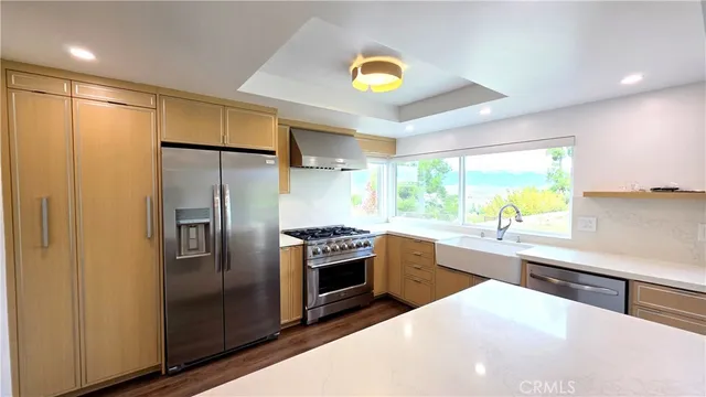 a kitchen with stainless steel appliances granite countertop a refrigerator and a sink