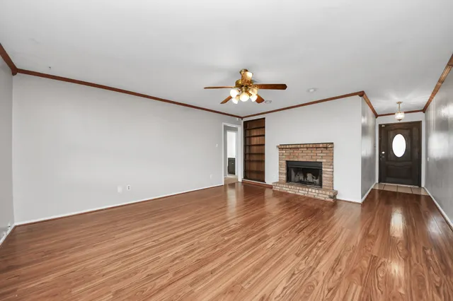 a view of a livingroom with wooden floor and a kitchen space