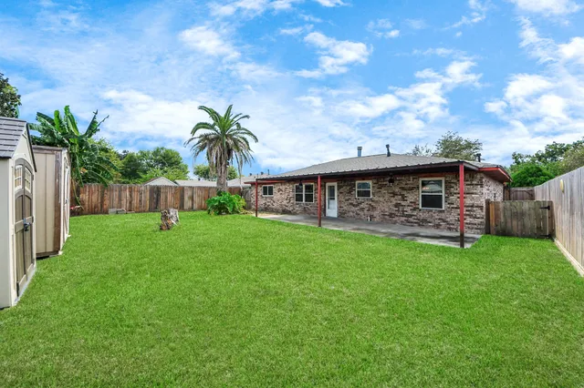a view of a house with backyard and sitting area