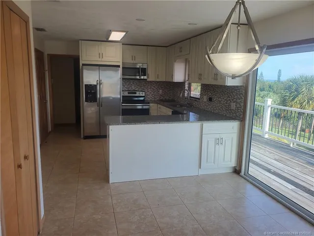 a kitchen with a sink a refrigerator and microwave