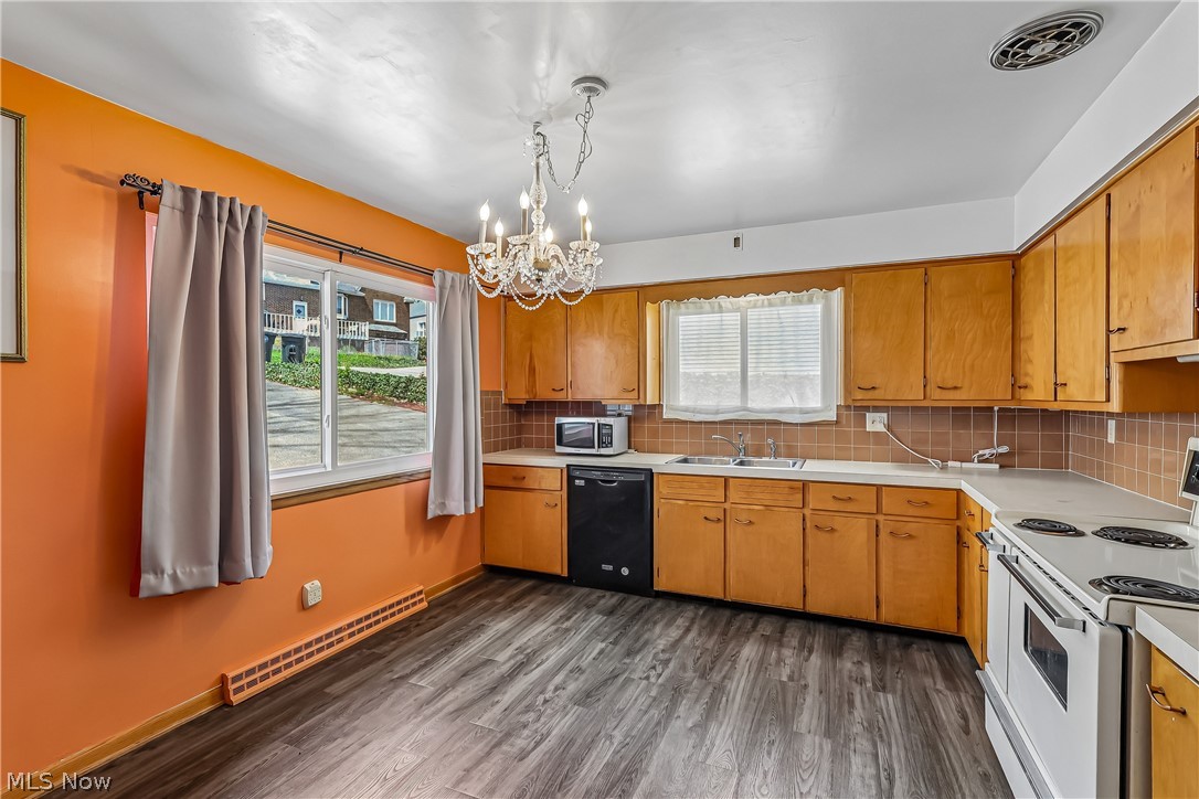 2060 6th Street Southwest Akron, OH 44314 - Photo 12 of 46 Eat-in kitchen with chandelier, sink, cabinets, dishwasher, stove and refigerator