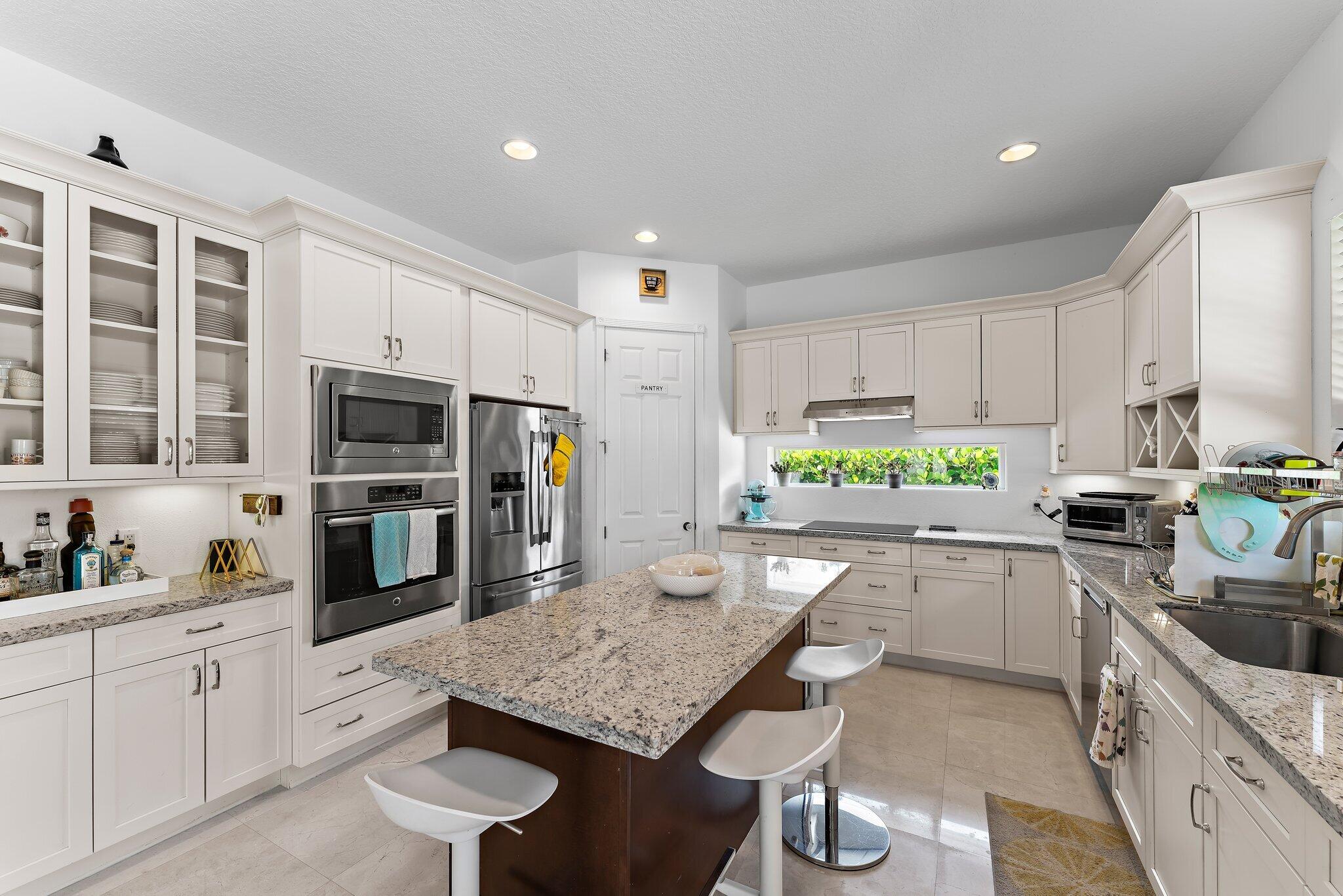 807 Xanadu Place Jupiter, FL 33477 - Photo 14 of 36 a kitchen with a sink a counter top space stainless steel appliances and cabinets
