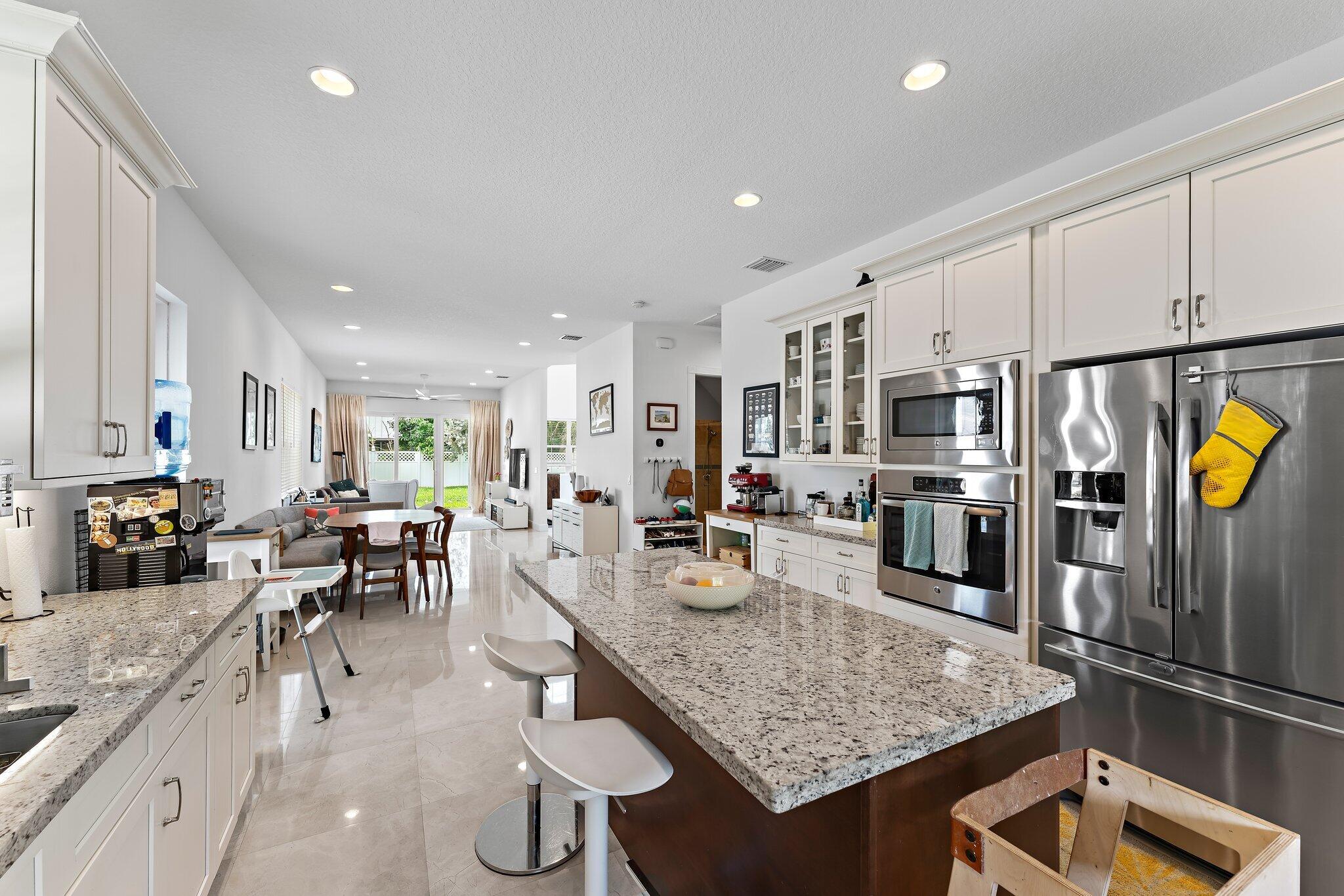 807 Xanadu Place Jupiter, FL 33477 - Photo 16 of 36 a kitchen with stainless steel appliances granite countertop a sink refrigerator and cabinets