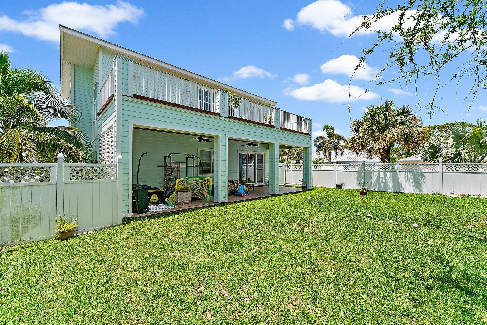 807 Xanadu Place Jupiter, FL 33477 - Photo 2 of 36 a view of a house with backyard porch and garden