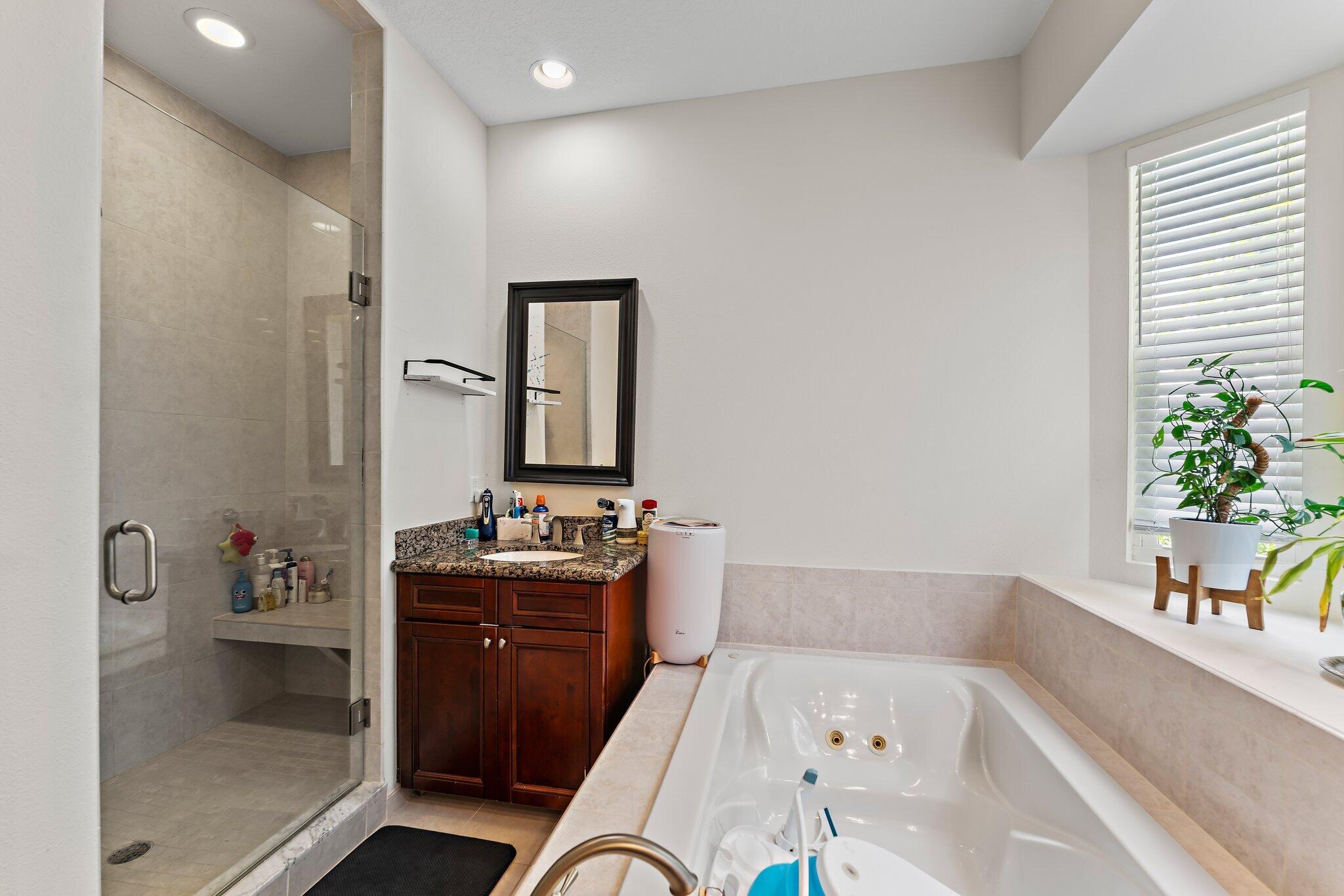 807 Xanadu Place Jupiter, FL 33477 - Photo 22 of 36 a bathroom with a bathtub sink and mirror