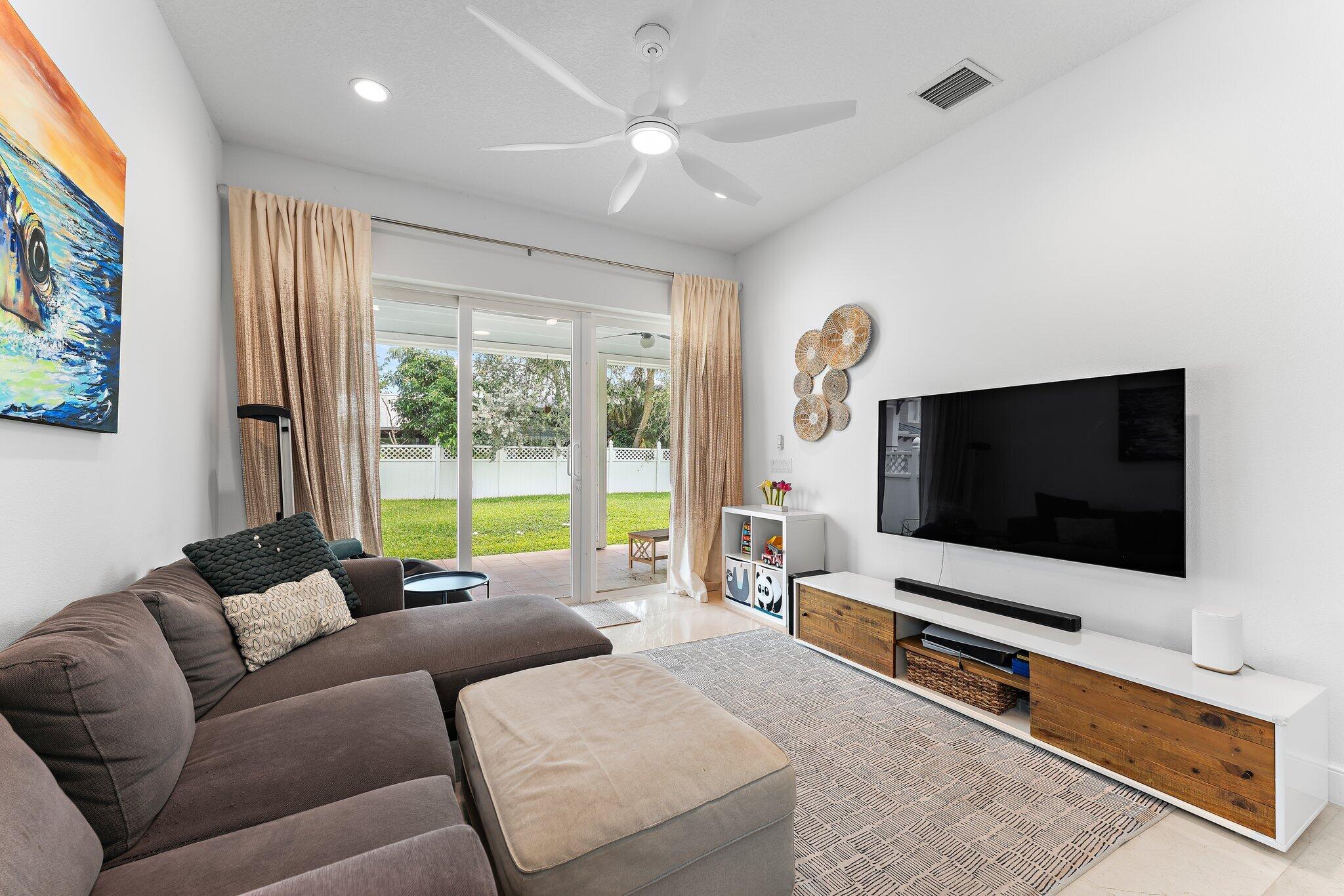 807 Xanadu Place Jupiter, FL 33477 - Photo 10 of 36 a living room with furniture and a flat screen tv