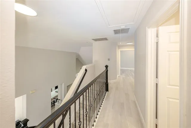 a view of a hallway with wooden floor and staircase