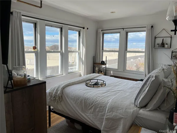 a bedroom with a bed and two windows