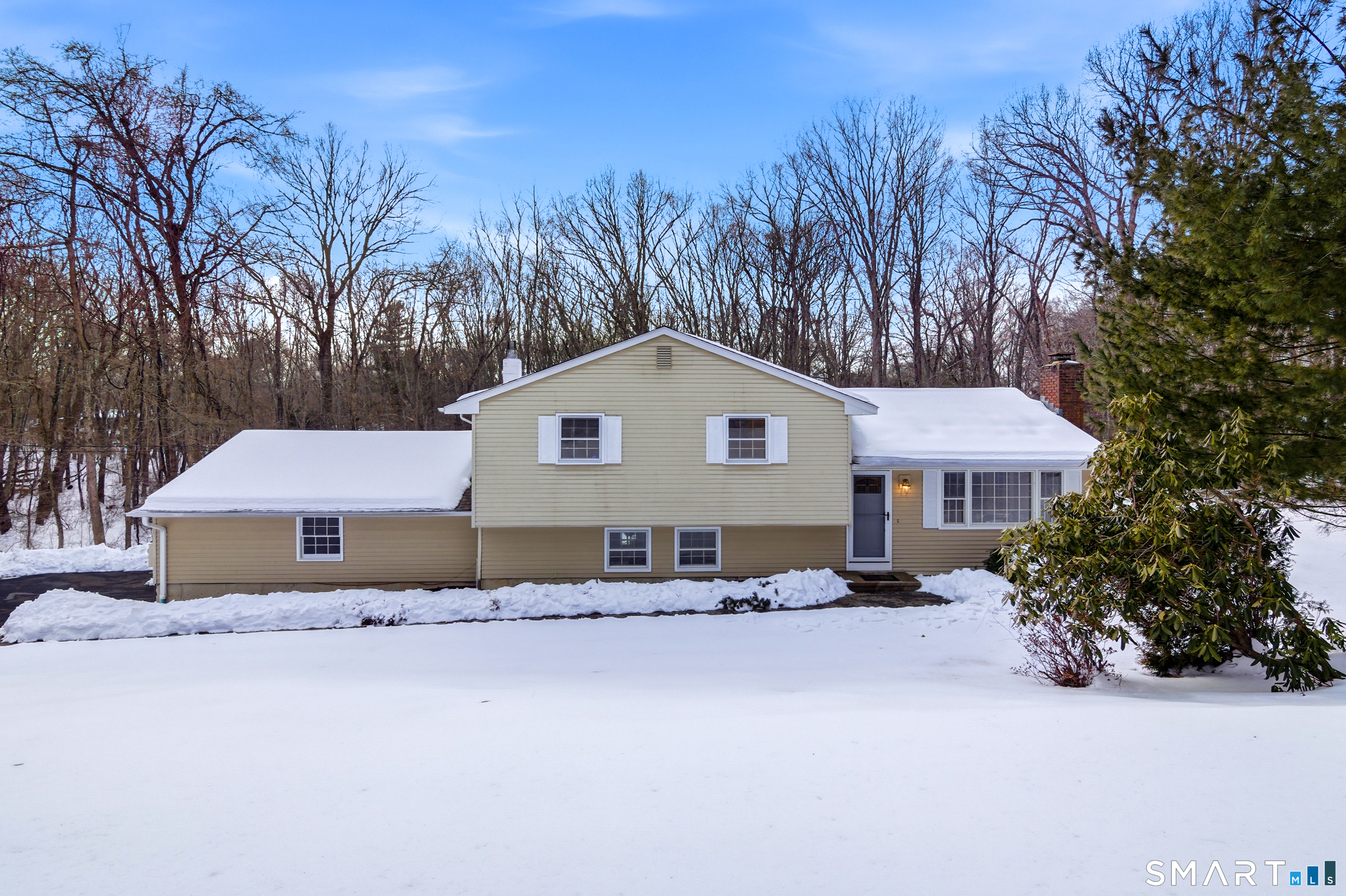 a front view of house with yard and trees in the background