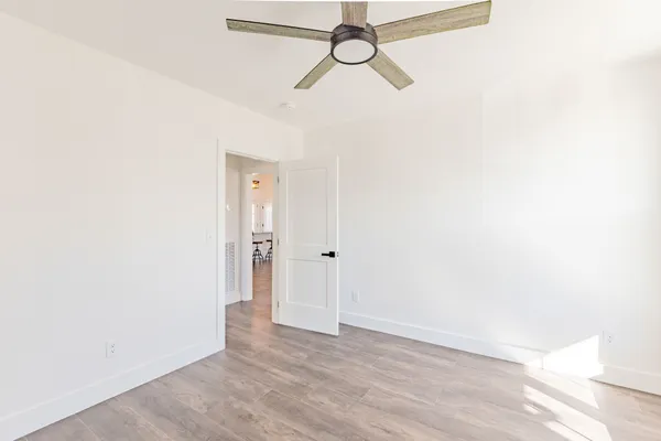 a view of a room with wooden floor and white walls