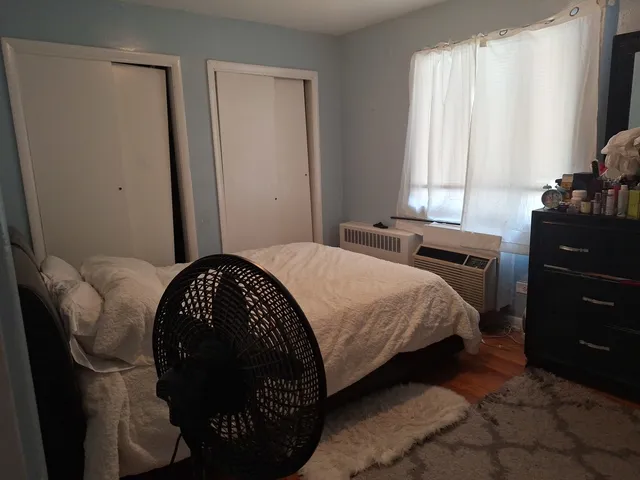 a bedroom with a bed a dresser and a window