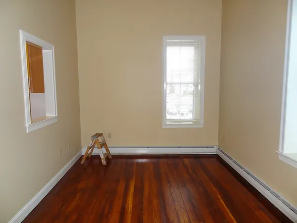 a room with wooden floor and windows