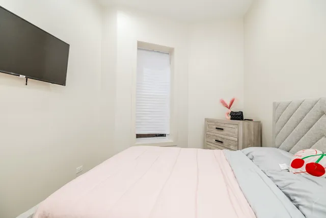 a bedroom with a bed and a flat screen tv