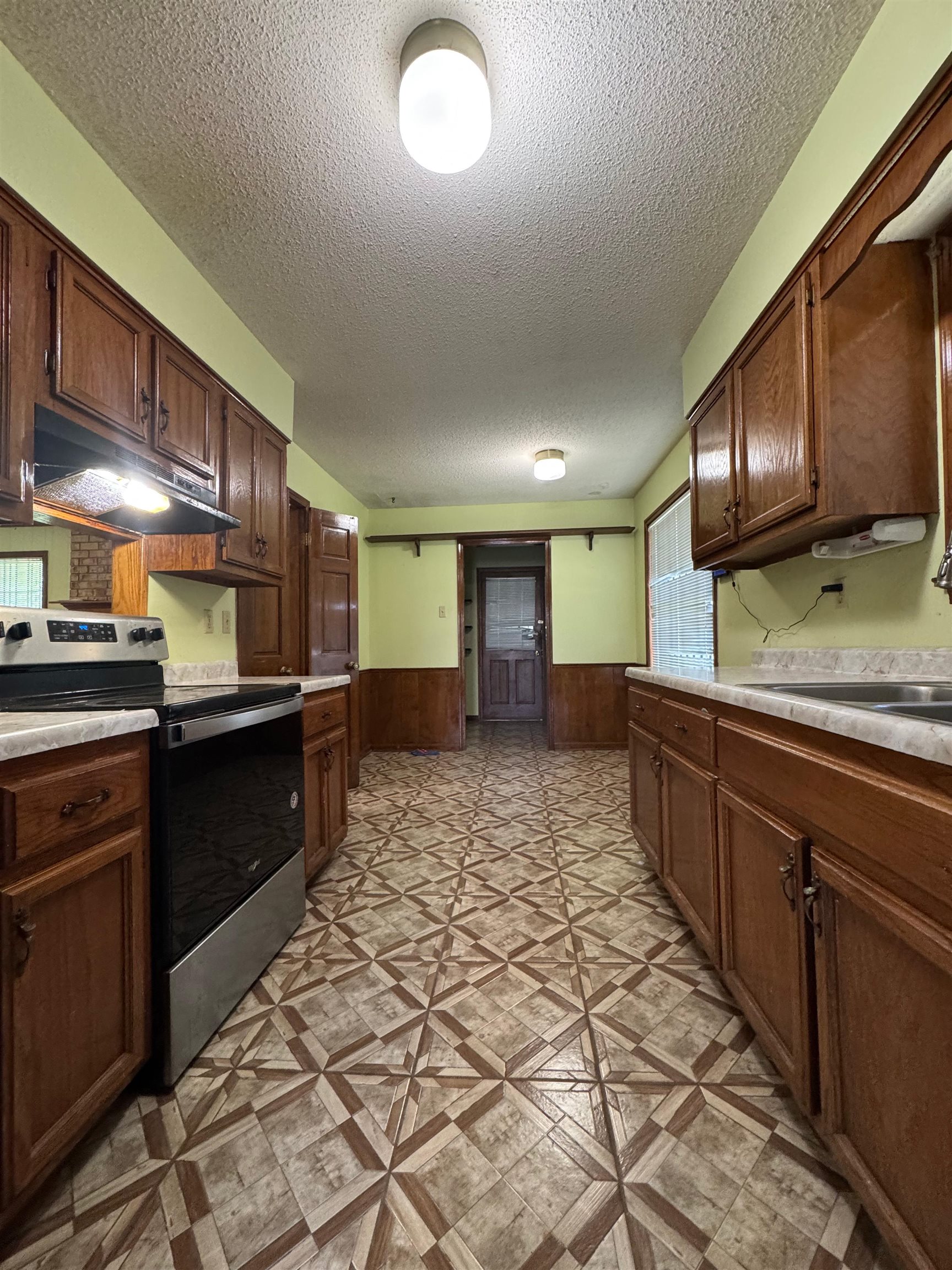 3213 Covington Pike Memphis, TN 38128 - Photo 12 of 17 a kitchen with stainless steel appliances kitchen island granite countertop a sink stove cabinets and granite counter top