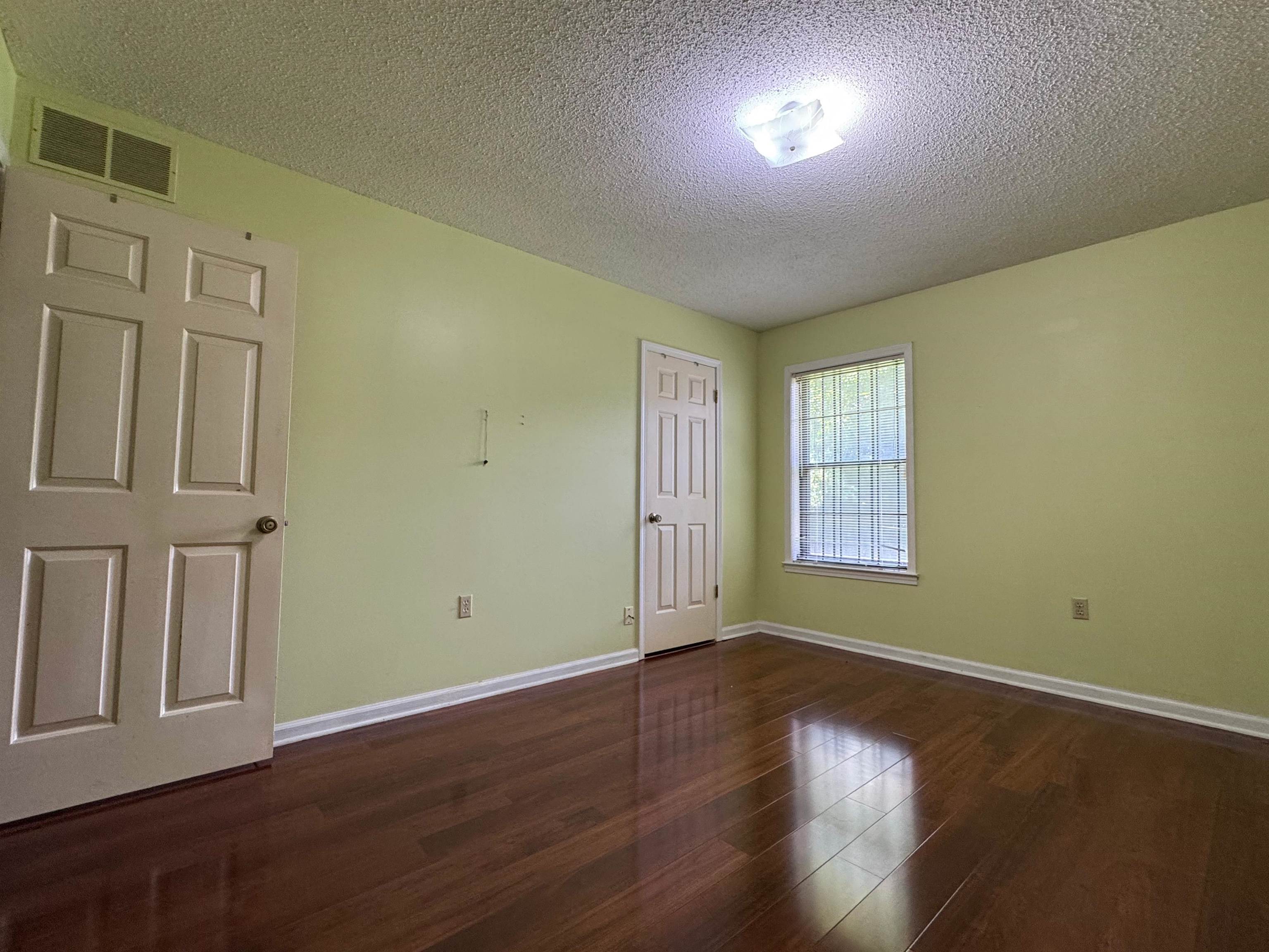 3213 Covington Pike Memphis, TN 38128 - Photo 9 of 17 an empty room with wooden floor and windows