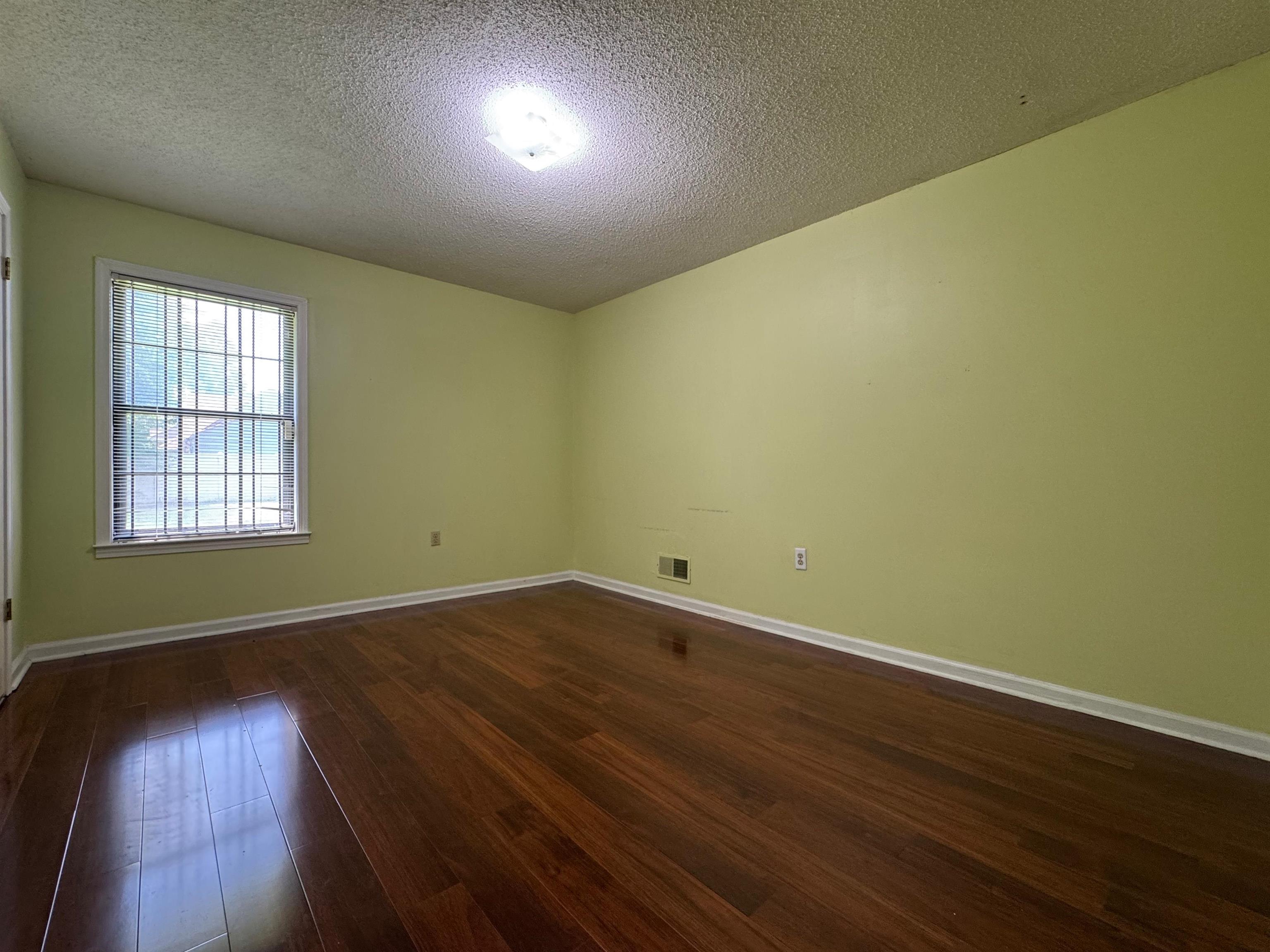 3213 Covington Pike Memphis, TN 38128 - Photo 10 of 17 an empty room with wooden floor and windows