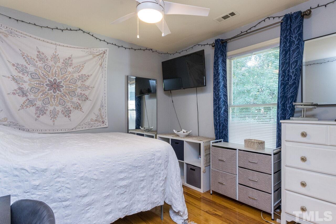 2400 Long And Winding Road Raleigh, NC 27603 - Photo 19 of 29 a bedroom with a bed and a flat tv screen on dresser